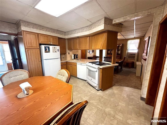 178 Fern Ave, Lyndhurst, NJ 07071 - kitchen featuring white appliances, a drop ceiling, a peninsula, light countertops, and brown cabinets