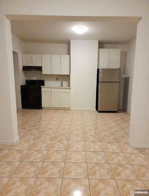 5001 Kennedy Blvd, North Bergen, NJ 07047 - kitchen featuring freestanding refrigerator, black range with gas cooktop, under cabinet range hood, a sink, and baseboards