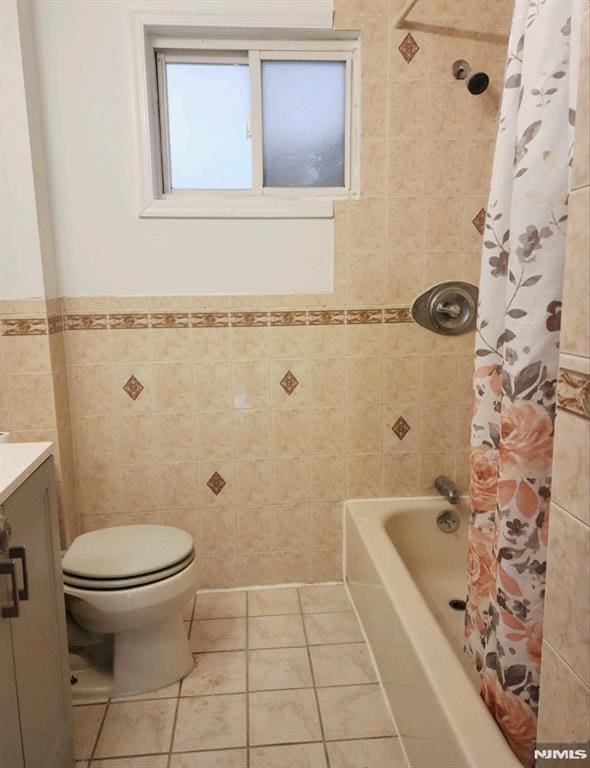5001 Kennedy Blvd, North Bergen, NJ 07047 - bathroom featuring tile patterned flooring, toilet, vanity, tile walls, and shower / bath combo