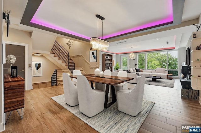26 Hudson Ter, Edgewater, NJ 07020 - dining area with a tray ceiling, a chandelier, stairs, and light wood-type flooring