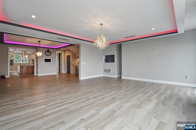 26 Hudson Ter, Edgewater, NJ 07020 - unfurnished living room featuring a chandelier, a tray ceiling, baseboards, light wood finished floors, and recessed lighting