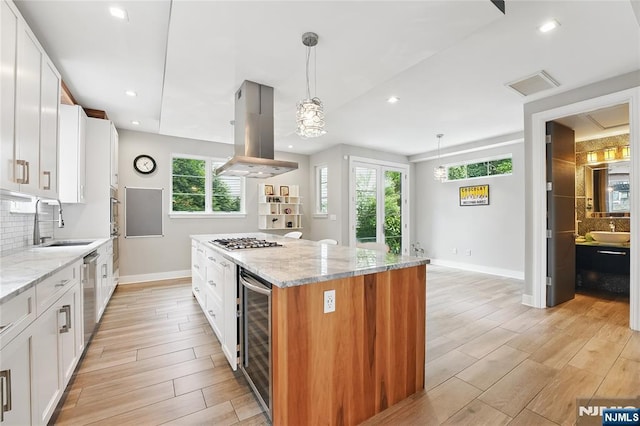 26 Hudson Ter, Edgewater, NJ 07020 - kitchen with island range hood, a sink, beverage cooler, stainless steel appliances, and baseboards
