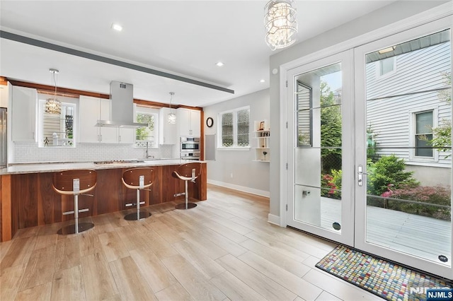 26 Hudson Ter, Edgewater, NJ 07020 - kitchen with island exhaust hood, baseboards, light countertops, decorative backsplash, and recessed lighting