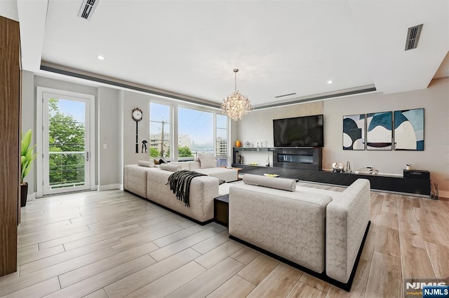 26 Hudson Ter, Edgewater, NJ 07020 - living room featuring a chandelier, light wood-style floors, recessed lighting, baseboards, and a tray ceiling
