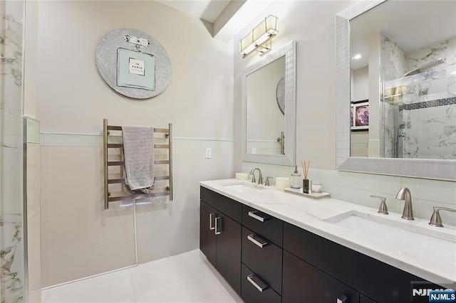 26 Hudson Ter, Edgewater, NJ 07020 - bathroom featuring a marble finish shower, a towel warmer, double vanity, radiator heating unit, and tile walls