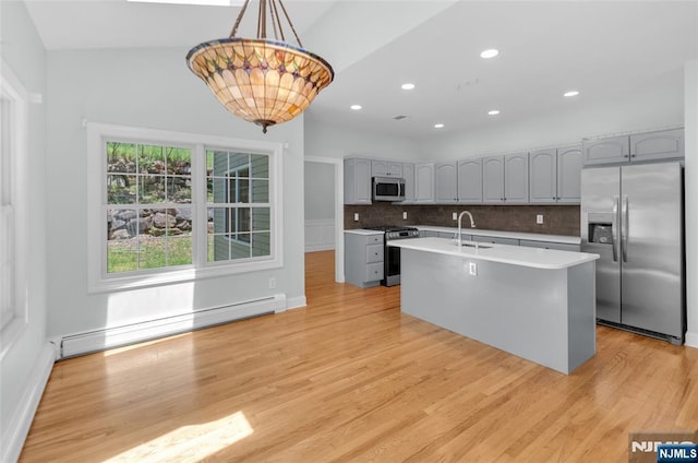 27 Tecumseh Trl, Oakland, NJ 07436 - kitchen with stainless steel appliances, a baseboard heating unit, a sink, backsplash, and light wood finished floors