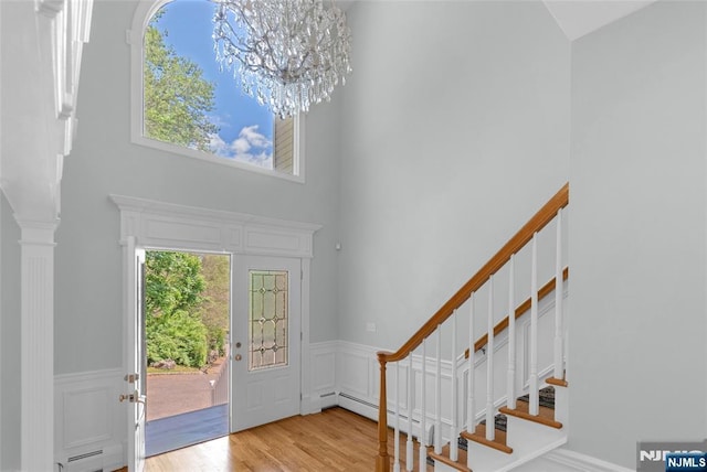 27 Tecumseh Trl, Oakland, NJ 07436 - foyer entrance featuring a towering ceiling, wood finished floors, a wainscoted wall, a chandelier, and stairs