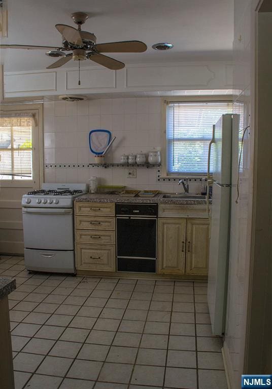 276 Galvan Pl, Bergenfield, NJ 07621 - kitchen featuring white appliances, a sink, ceiling fan, light tile patterned floors, and backsplash