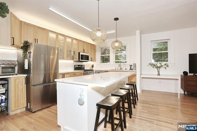 427 Stockton Pl Unit 2, Englewood, NJ 07631 - kitchen featuring appliances with stainless steel finishes, light wood-type flooring, tasteful backsplash, and light countertops