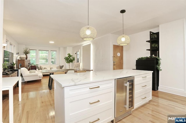 427 Stockton Pl Unit 2, Englewood, NJ 07631 - kitchen featuring beverage cooler, open floor plan, white cabinetry, light stone countertops, and light wood-type flooring