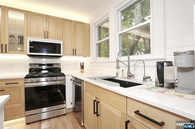 427 Stockton Pl Unit 2, Englewood, NJ 07631 - kitchen with stainless steel appliances, a sink, light brown cabinets, and tasteful backsplash