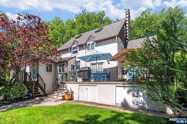 747 Mildred St, Teaneck, NJ 07666 - back of house with stucco siding, a chimney, and a yard