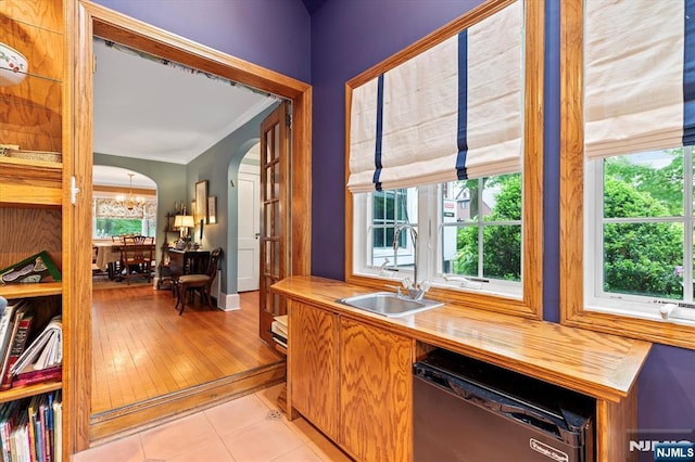 747 Mildred St, Teaneck, NJ 07666 - kitchen with black dishwasher, a sink, arched walkways, crown molding, and butcher block counters