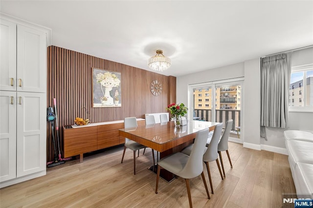 2180 Center 4B, Fort Lee, NJ 07024 - dining space featuring a chandelier, an accent wall, light wood-style floors, and baseboards