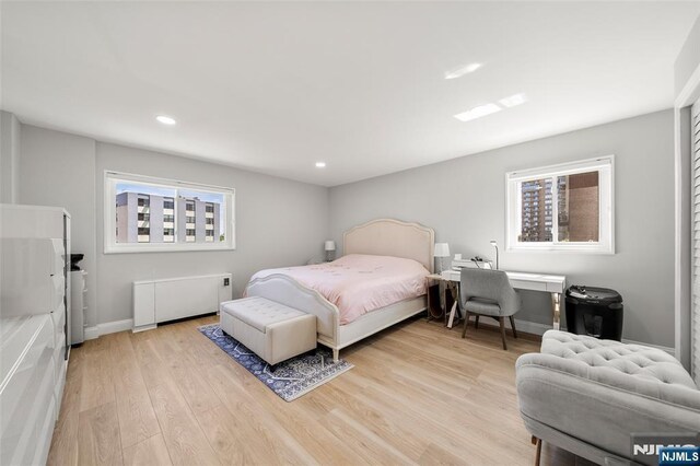 2180 Center 4B, Fort Lee, NJ 07024 - bedroom featuring radiator, multiple windows, light wood-style floors, recessed lighting, and baseboards