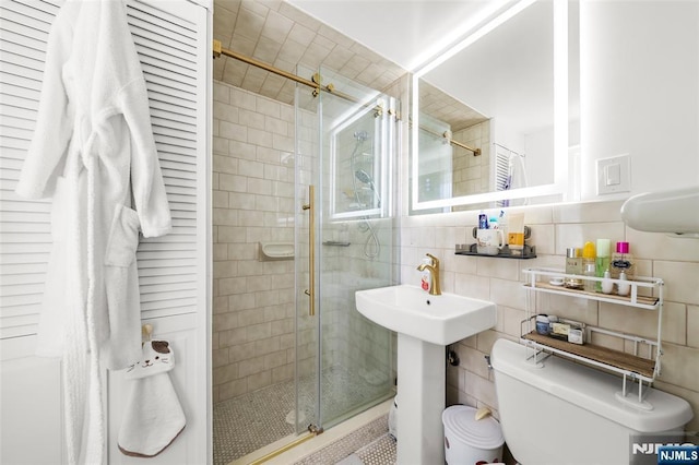 2180 Center 4B, Fort Lee, NJ 07024 - full bathroom with a shower stall, toilet, tile walls, a sink, and decorative backsplash