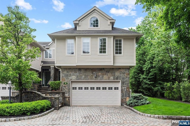 10 Kensington Ct, Tenafly, NJ 07670 - view of front of home with stone siding, an attached garage, decorative driveway, a front yard, and a shingled roof