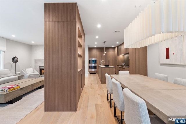 10 Kensington Ct, Tenafly, NJ 07670 - dining room featuring light wood finished floors, recessed lighting, and a fireplace
