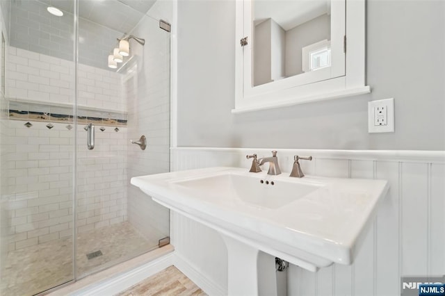 15 Fred St, Old Tappan, NJ 07675 - bathroom featuring a shower stall, wainscoting, wood finished floors, and a decorative wall