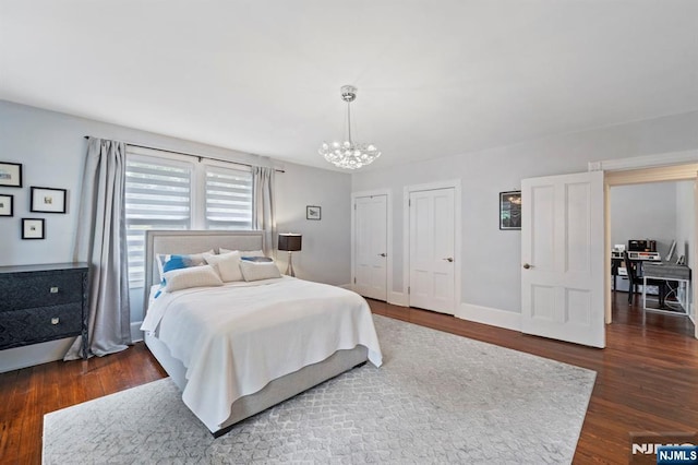 296 Highfield Ln, Nutley, NJ 07110 - bedroom featuring a chandelier, dark wood-style floors, multiple closets, and baseboards