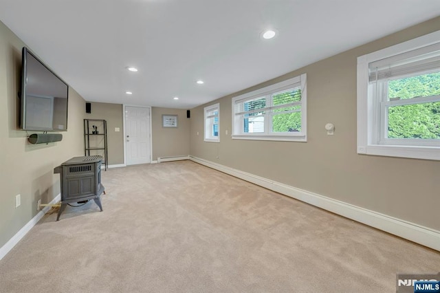 248 Camden St, Oradell, NJ 07649 - unfurnished living room featuring a wood stove, baseboards, recessed lighting, and light carpet