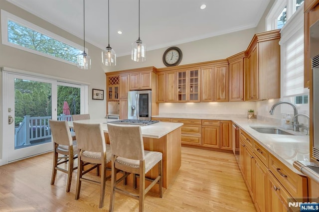 248 Camden St, Oradell, NJ 07649 - kitchen featuring appliances with stainless steel finishes, a sink, a center island, a kitchen breakfast bar, and light countertops