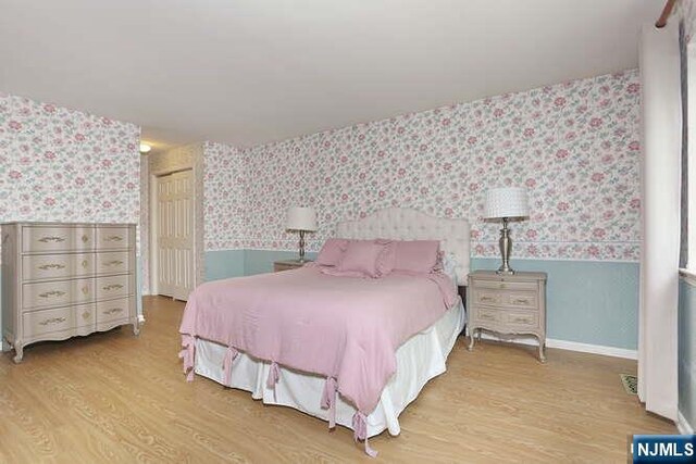 103 Mark Twain Way, Mahwah, NJ 07430 - bedroom featuring wallpapered walls, wood finished floors, wainscoting, a closet, and baseboards