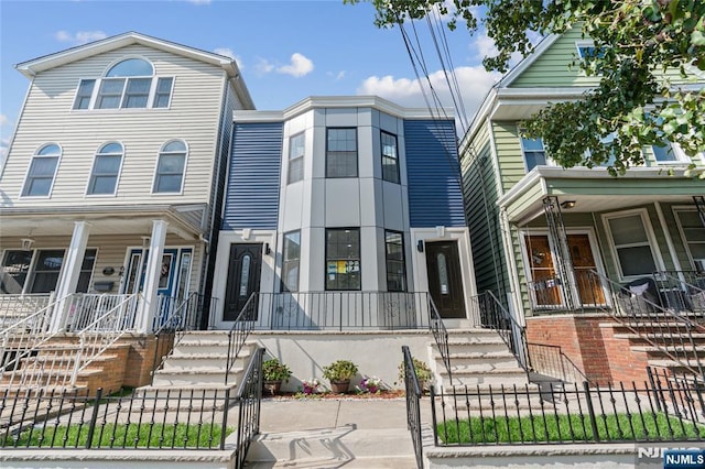 133 4th St, Bayonne, NJ 07002 - view of property featuring a porch, a fenced front yard, stairs, and a gate