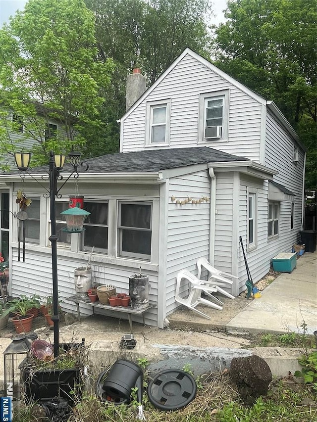 67-69 Garret St, Paterson, NJ 07501 - back of house featuring cooling unit, a chimney, and a shingled roof