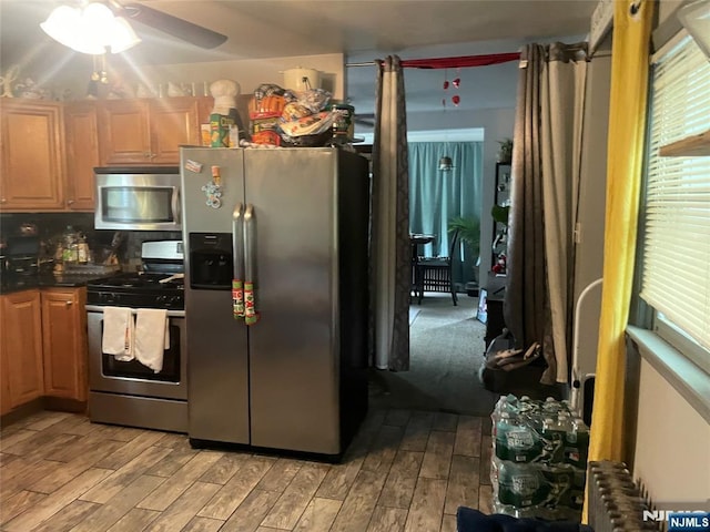 67-69 Garret St, Paterson, NJ 07501 - kitchen featuring stainless steel appliances, radiator, light wood-style flooring, a ceiling fan, and dark countertops