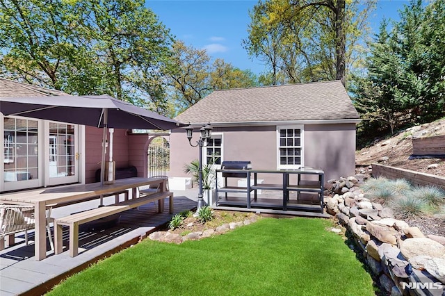 263 Standish Rd, Ridgewood, NJ 07450 - rear view of house featuring stucco siding, a deck, roof with shingles, and a lawn