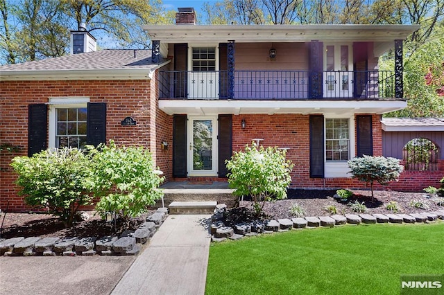 263 Standish Rd, Ridgewood, NJ 07450 - view of front of house with a balcony, a chimney, brick siding, and a front yard