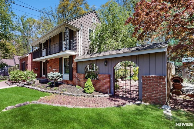263 Standish Rd, Ridgewood, NJ 07450 - view of front facade with a balcony, brick siding, a front yard, and a gate