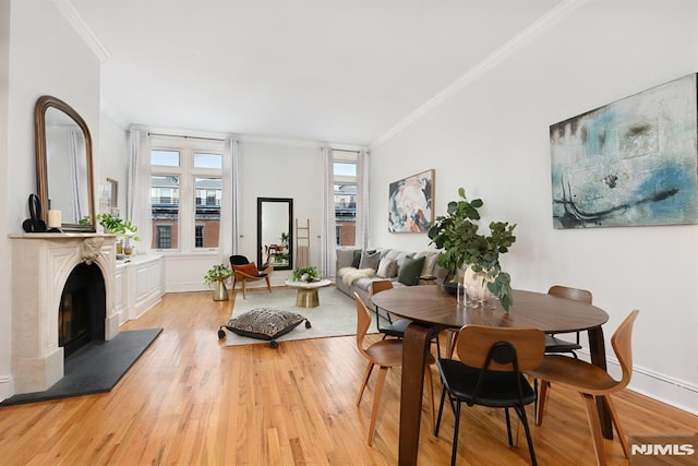 167 Wayne St Unit 407, Jersey City, NJ 07302 - dining room featuring ornamental molding, light wood-style floors, a fireplace with raised hearth, and baseboards