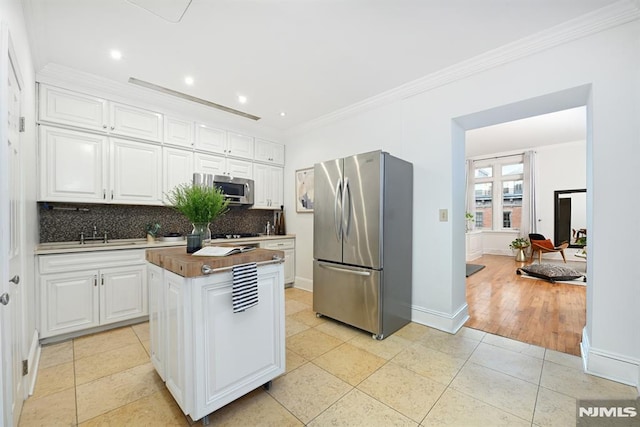 167 Wayne St Unit 407, Jersey City, NJ 07302 - kitchen featuring stainless steel appliances, backsplash, a kitchen island, white cabinets, and crown molding