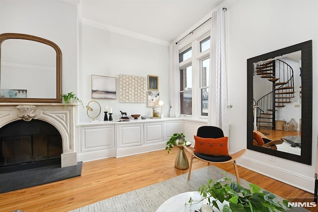167 Wayne St Unit 407, Jersey City, NJ 07302 - living room featuring crown molding, light wood-style flooring, stairway, and a glass covered fireplace