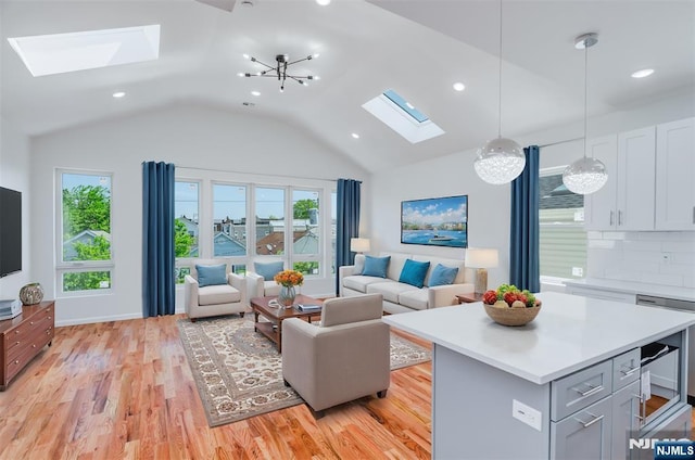 85 Myrtle Ave, Jersey City, NJ 07305 - living room featuring a skylight, light wood-style flooring, lofted ceiling, recessed lighting, and a chandelier