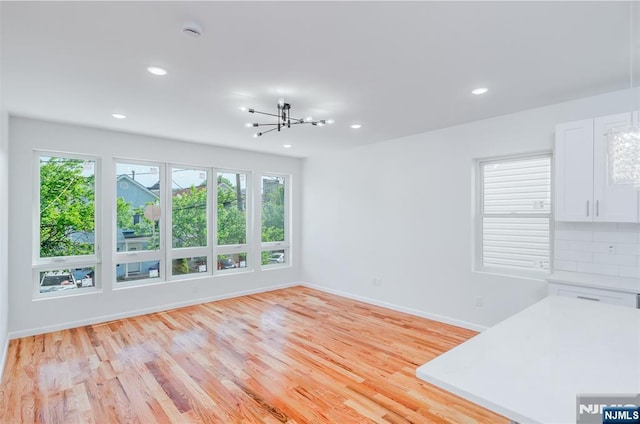 85 Myrtle Ave, Jersey City, NJ 07305 - unfurnished living room featuring a chandelier, baseboards, light wood-style floors, and recessed lighting