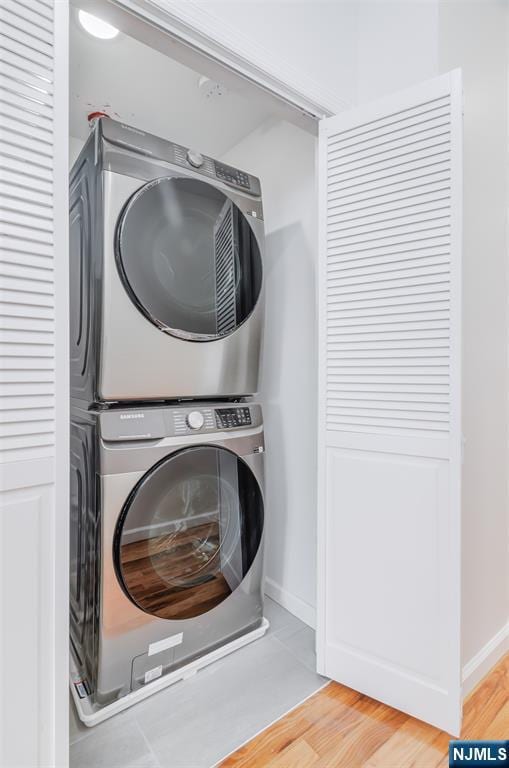 85 Myrtle Ave, Jersey City, NJ 07305 - washroom with stacked washer / drying machine, light wood-style floors, and baseboards