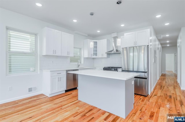 85 Myrtle Ave, Jersey City, NJ 07305 - kitchen with stainless steel appliances, wall chimney range hood, a kitchen island, light wood-type flooring, and recessed lighting