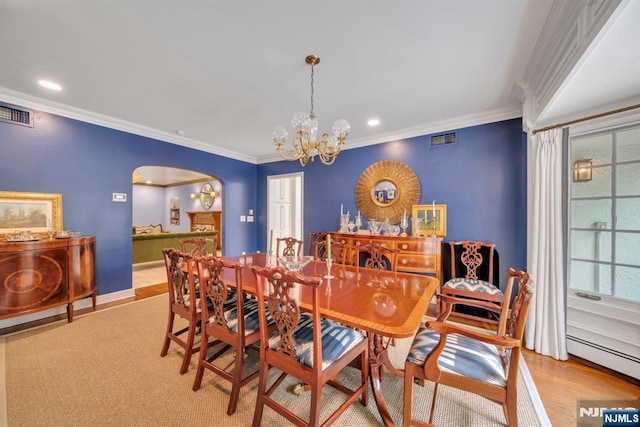 76 Wildwood Rd, Ridgewood, NJ 07450 - dining area with arched walkways, a chandelier, wood finished floors, baseboard heating, and crown molding