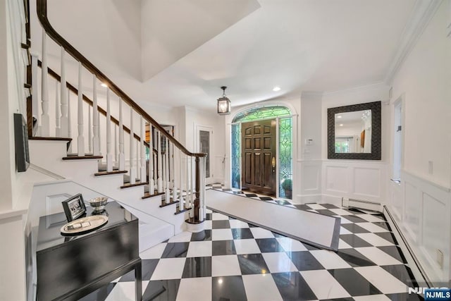 76 Wildwood Rd, Ridgewood, NJ 07450 - foyer entrance with a baseboard heating unit, crown molding, stairs, tile patterned floors, and a decorative wall