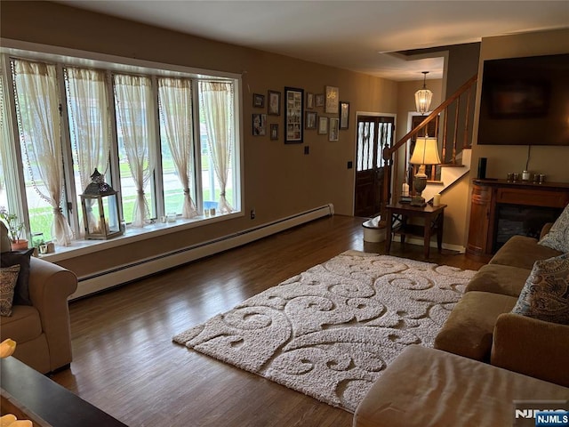 32 Northgate, Wanaque, NJ 07465 - living room with a baseboard heating unit, wood finished floors, stairway, and baseboards
