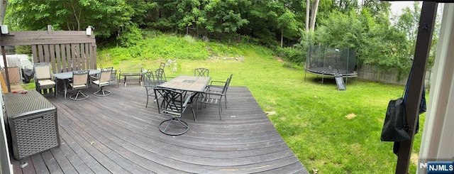 32 Northgate, Wanaque, NJ 07465 - wooden deck with outdoor dining area, a trampoline, and a lawn