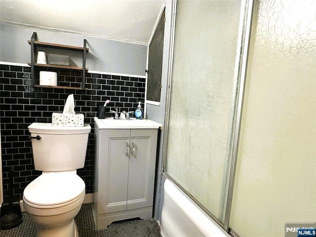 84 Haring St, Bergenfield, NJ 07621 - full bathroom with tile walls, toilet, vanity, tile patterned flooring, and combined bath / shower with glass door