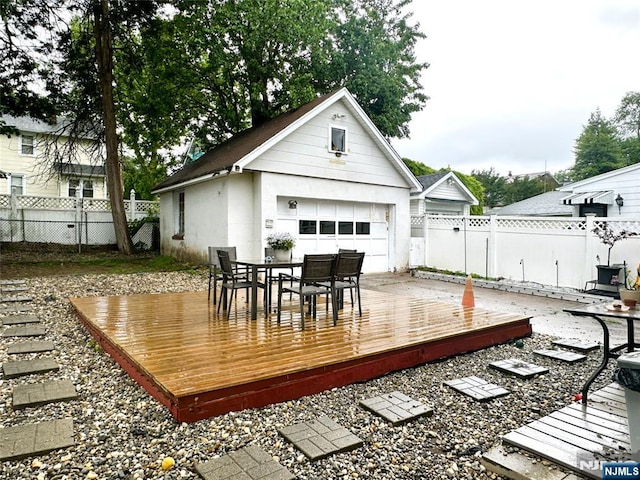 84 Haring St, Bergenfield, NJ 07621 - wooden deck featuring a garage, a fenced backyard, outdoor dining area, and an outbuilding