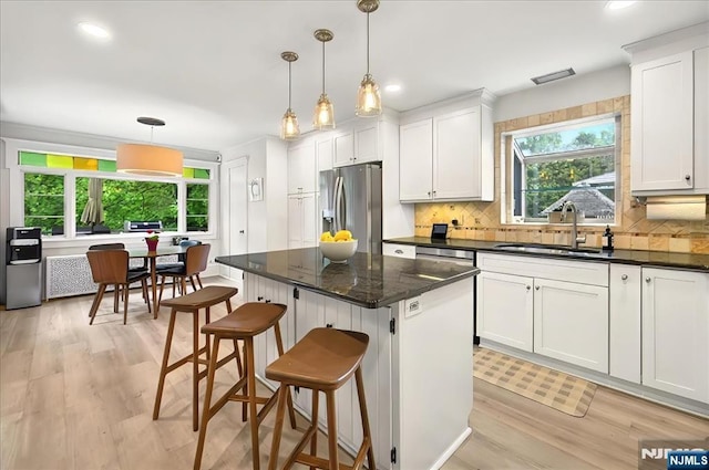 246 Park Ave, Allendale, NJ 07401 - kitchen featuring stainless steel fridge with ice dispenser, a sink, light wood-style flooring, backsplash, and a breakfast bar