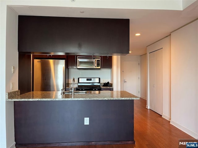 615 Hudson Park, Edgewater, NJ 07020 - kitchen featuring appliances with stainless steel finishes, a peninsula, dark wood-style floors, light stone countertops, and recessed lighting