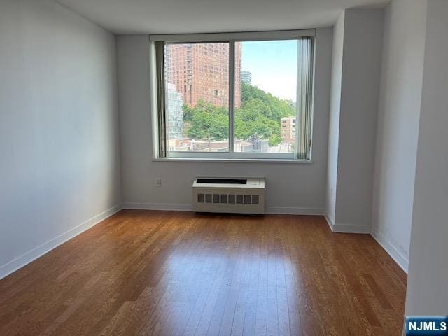 615 Hudson Park, Edgewater, NJ 07020 - empty room featuring radiator, wood finished floors, and baseboards