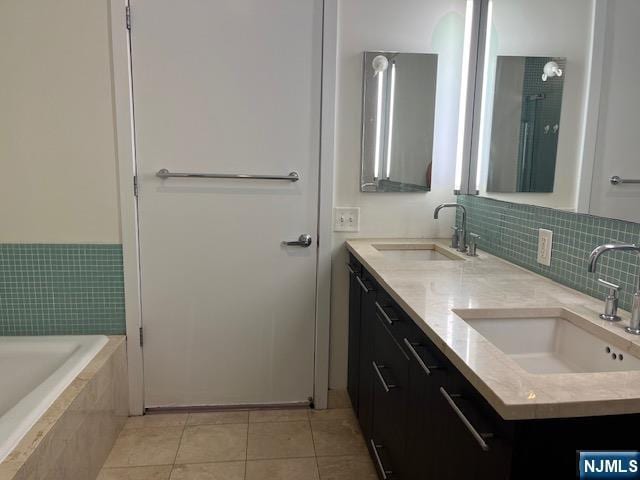 615 Hudson Park, Edgewater, NJ 07020 - full bathroom featuring tile patterned floors, tiled tub, double vanity, and decorative backsplash